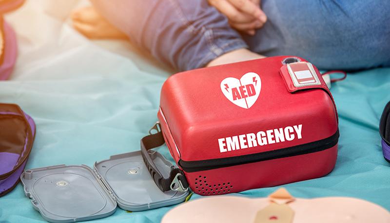 Automated External Defibrillator (AED) Box on the Mat in Emergency CPR Training Course - First Aid Concept