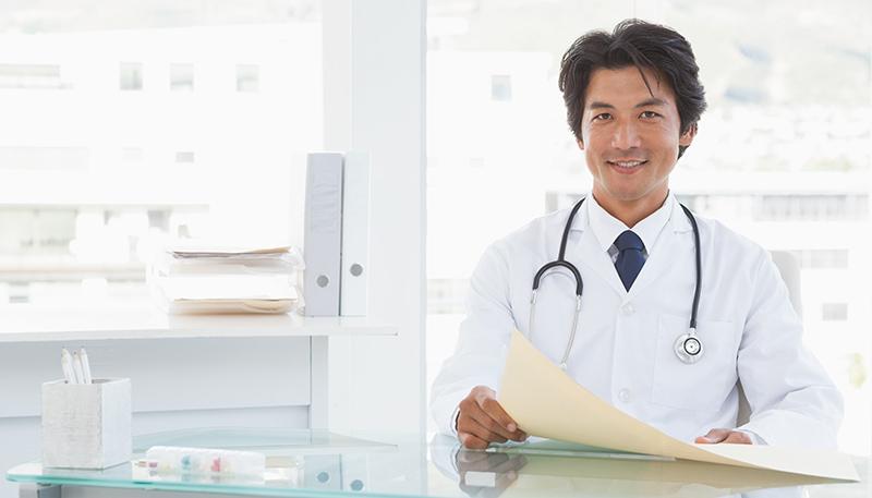 Smiling doctor sitting at his desk