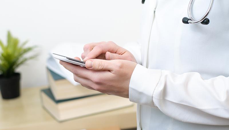 A female doctor texting on smartphone