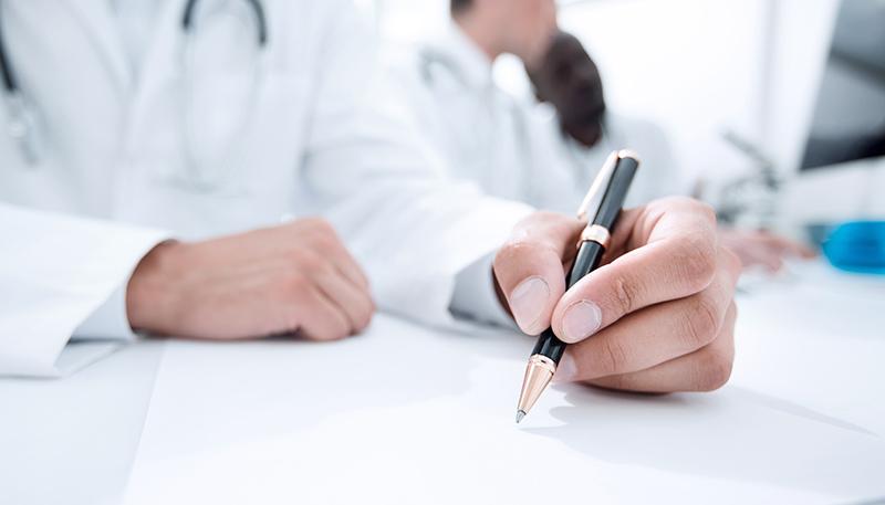 close up.doctor writing something in the lab journal.