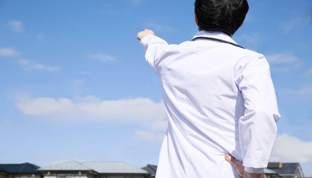 空を指さしている男性医師