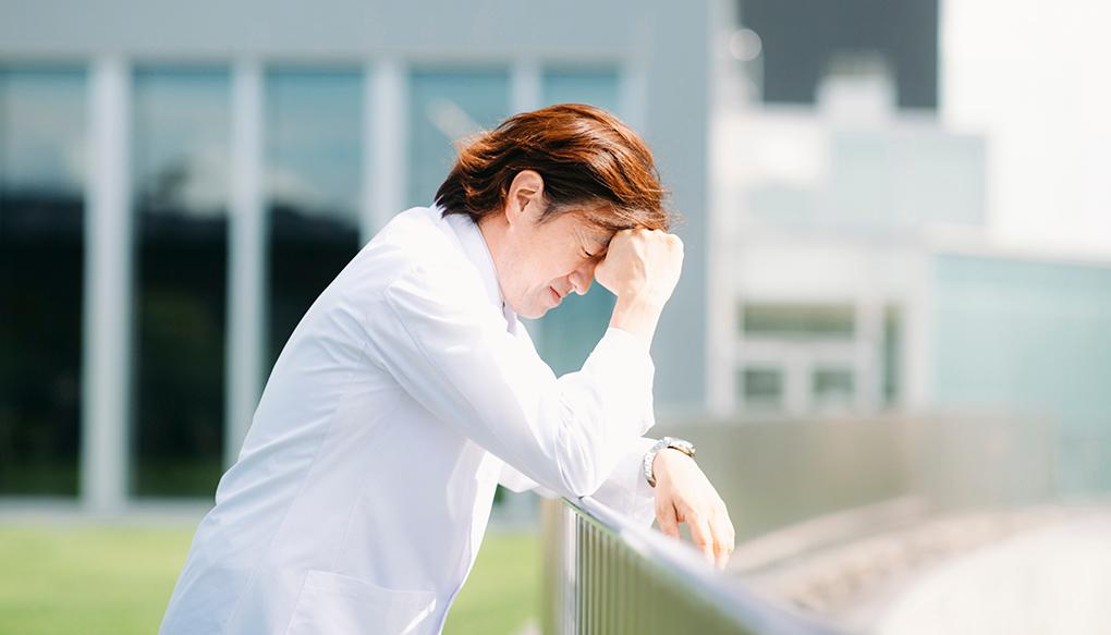 ペイシェントハラスメントについて病院の屋上で思い悩む男性医師