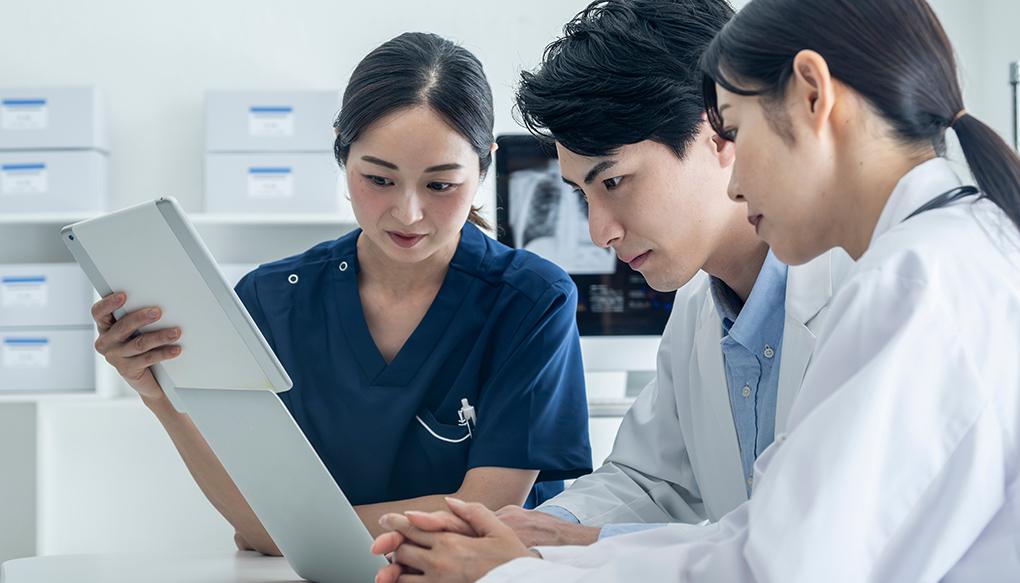 ペイシェントハラスメントの対応マニュアルを読む3人の若い男女の医師