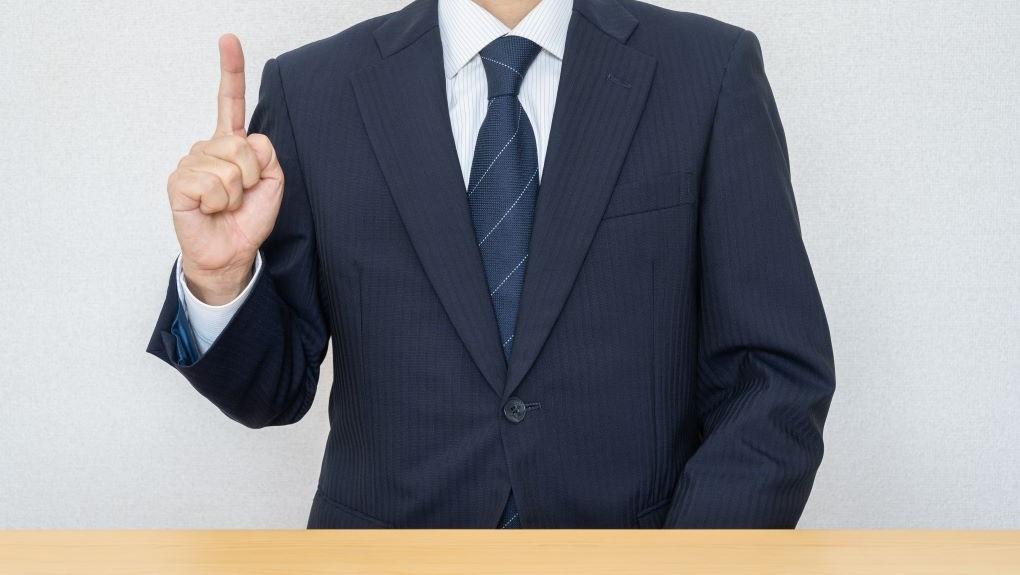 ポイントを示唆する人差し指を出している男性の写真