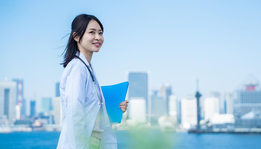 笑顔で外を歩く女性の医師
