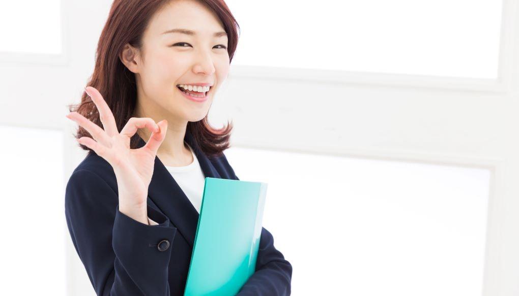 女性のコンサルタントが右手でOKマークを作っている写真