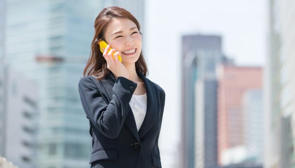 女性のコンサルタントが外で電話をしている写真