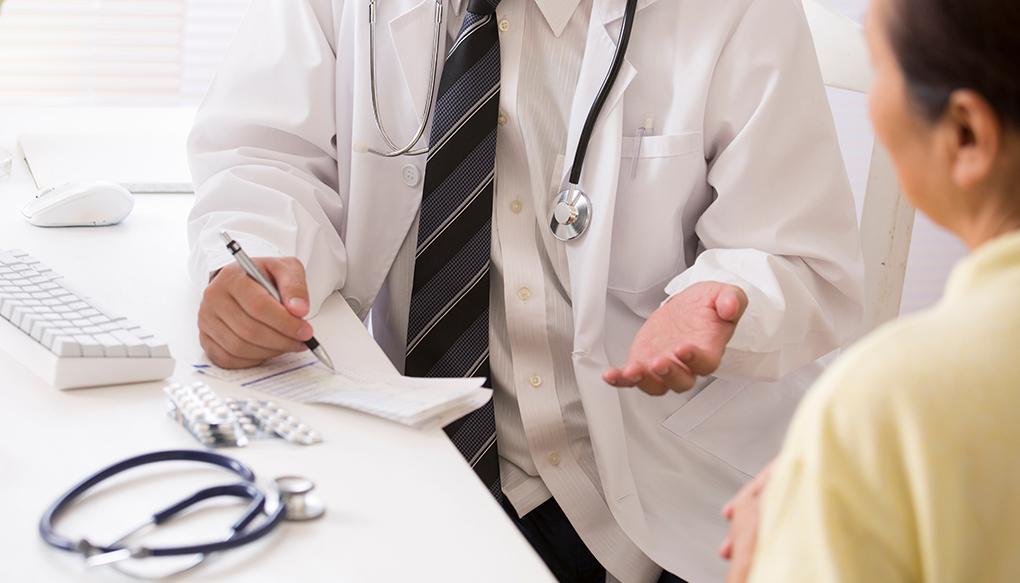 診察し、高齢者に薬を処方する日本人の医師