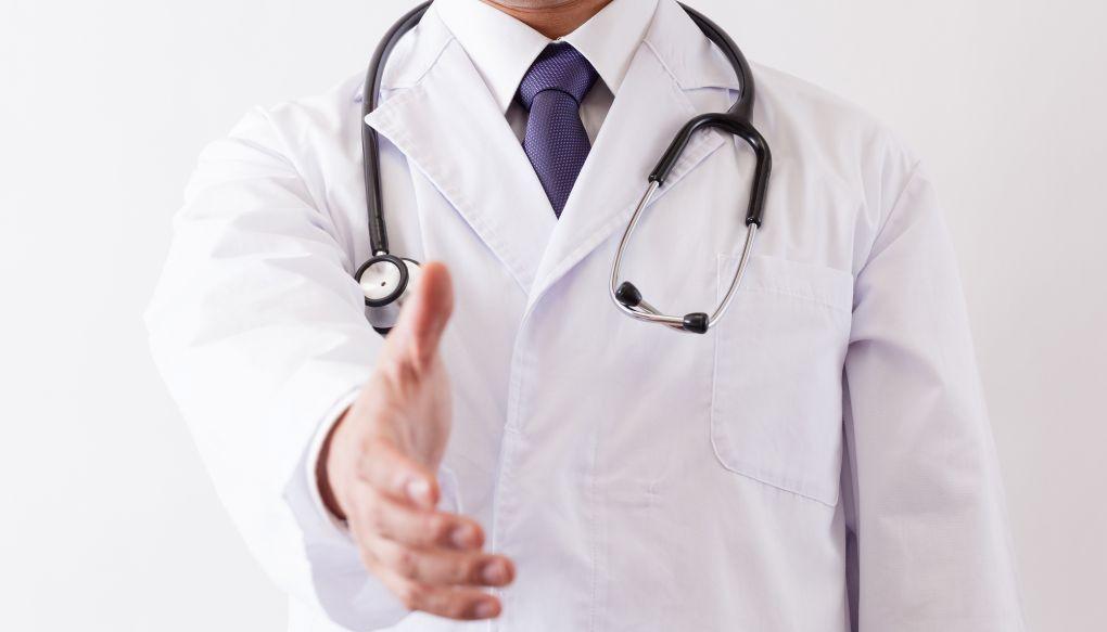 医師が握手を求めている写真