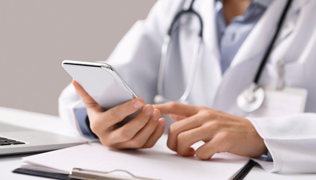 スマートフォンで調べ物をしている医師の画像