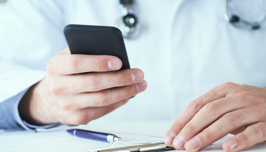 スマートフォンで調べ物をする医師の写真