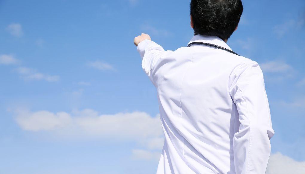 空を指さしている医師の写真