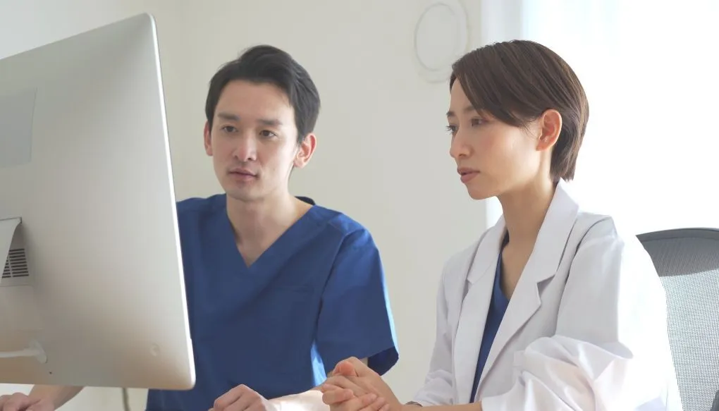 男性と女性の医師が並んで話している様子